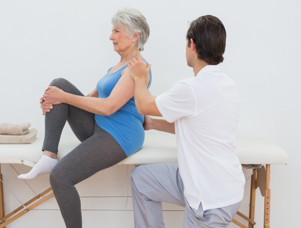 Picture of physiotherapist assisting a woman to improve her posture.